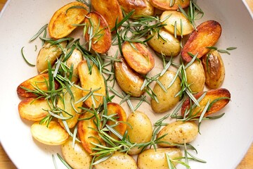 cooking fried potatoes in white pan