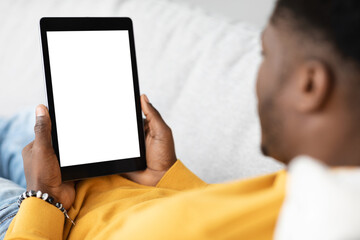 Unrecognizable black guy using digital tablet with empty screen