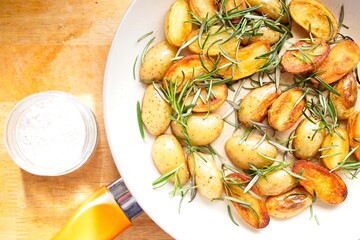 cooking fried potatoes in white pan