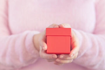 woman giving a red box gift for a holiday