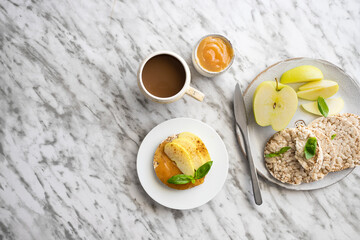 Top view of crunchy buckwheat and rice snack with almond butter and apple on the table.