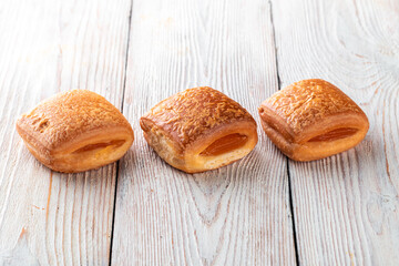 Freshly baked tasty bun on a white wooden table. Tasty baked goods straight from the bakery. White...
