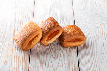 Freshly baked tasty bun on a white wooden table. Tasty baked goods straight from the bakery. White background.