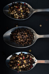 Various colored pepercorns on a dark background