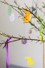 Blooming cherry branches decorated with colorful ribbons with Easter eggs, decorative rabbits, Happy Easter, holiday decoration