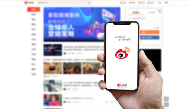 Weibo app on smartphone screen and Weibo web background on computer screen : Chiang Mai, Thailand, January 1, 2022.