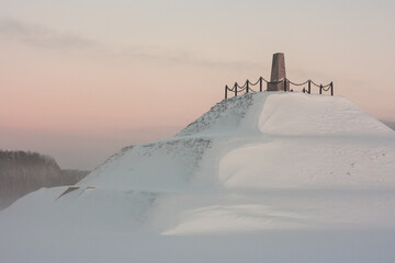 Winter landscape. Monument to an artificially constructed mountain who is rough with snow.