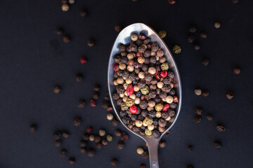 Various colored pepercorns on a dark background