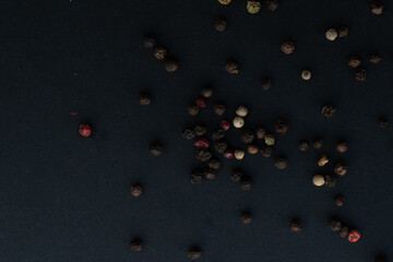 Various colored pepercorns on a dark background