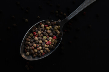 Various colored pepercorns on a dark background