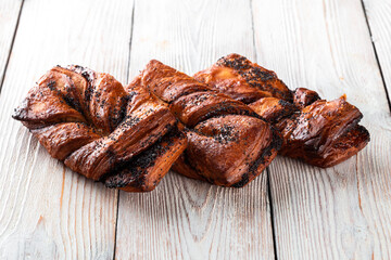 Freshly baked tasty bun on a white wooden table. Tasty baked goods straight from the bakery. White background.