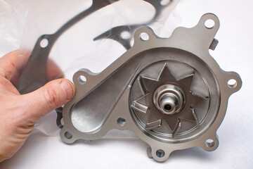 a view of the impeller of a new water pump of a liquid cooling system of a car with a gasket and a...