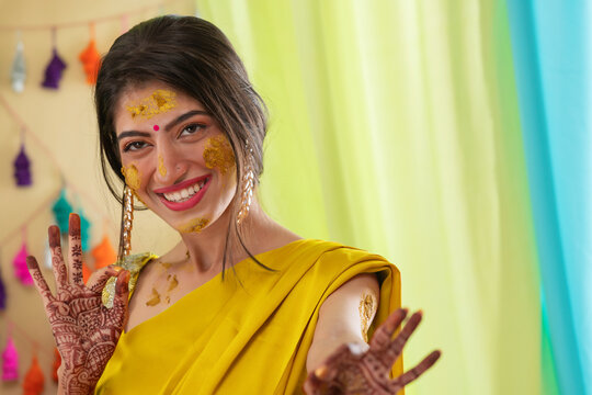 Close-up portrait of an Indian bride with turmeric applied on face