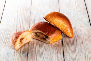 Freshly baked tasty bun on a white wooden table. Tasty baked goods straight from the bakery. White background.