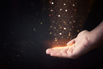 Praying male hand with golden shining lights