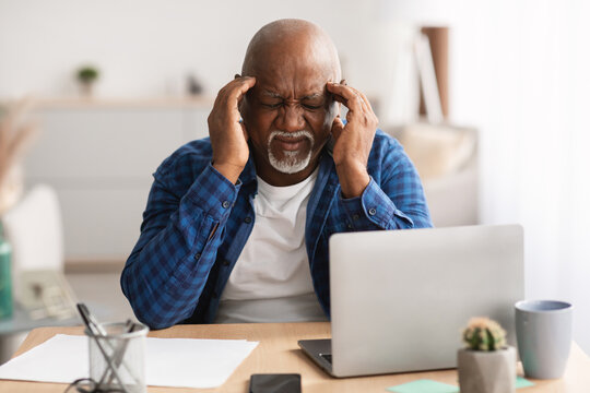 Senior Black Businessman Having Headache Touching Temples Sitting In Office - Powered by Adobe