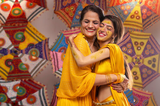 Portrait of Mother and daughter hugging each other during haldi ceremony