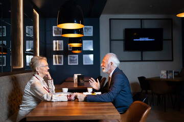 Elderly wife and husband having a conversation in a exclusive restaurant
