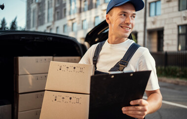 Delivery of a box of products and goods to your home. Employee in uniform logistics company. Fast...