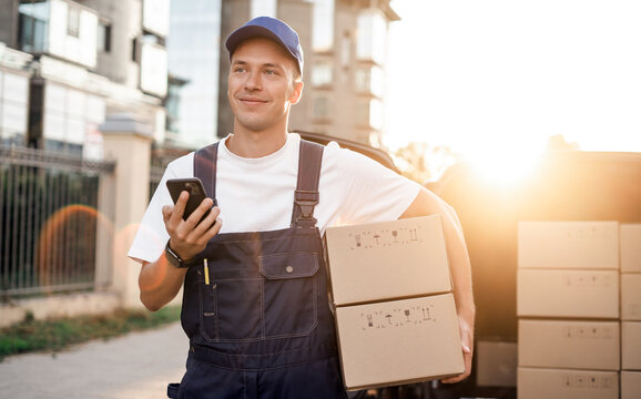 Employee in uniform logistics company.  Fast delivery of the goods. Delivery of a box of products and goods to your home. The driver of the courier service.