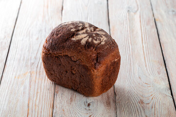 Freshly baked tasty bread on a white wooden table. Tasty baked goods straight from the bakery. White background.
