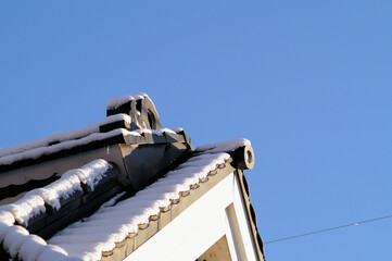 雪の朝の風景　薄く雪をかぶった古民家の屋根