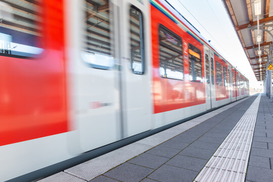 zug s-bahn f&auml;hrt an bahnsteig ein schnell