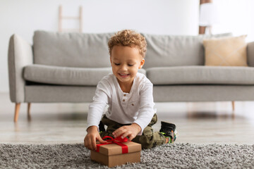 African American Little Boy Opening Gift Box Sitting At Home