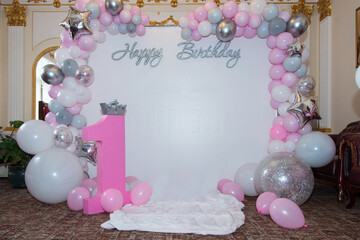 
Photo zone Happy Birthday with balloons and number one, white and pink decor.