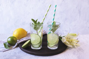 Detox water from citrus, mint leaves and cucumber slices in glasses, on a light background, healthy drinks, water for weight loss