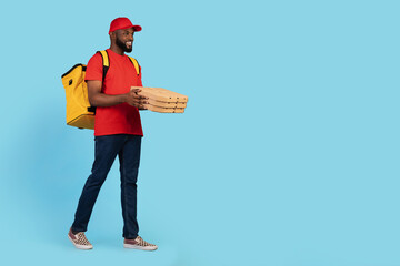 Young Smiling Black Courier Guy Wearing Thermal Backpack Walking With Pizza Boxes