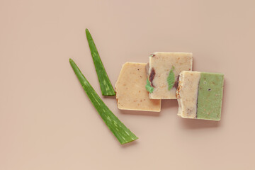 Handmade organic natural soap and aloe vera leaves on a beige background. Top view. Flat lay