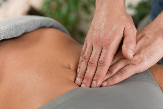 Closeup of masseur man's hands during stomach massage
