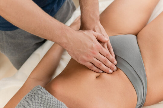Closeup of masseur man's hands during stomach massage