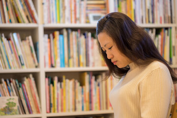 図書館で本を読んでいる若い女性