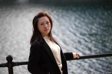 冬の公園の川の堤防で散歩している若い女性の姿