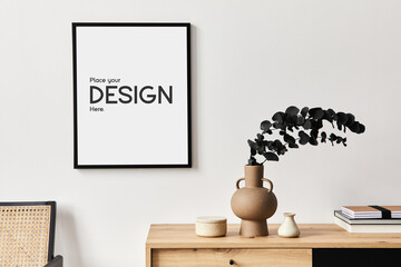 Stylish interior of living room with mock up poster frame, wooden commode, book, eucalyptus leaf in...