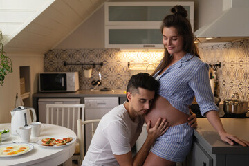 Young and sensual couple waiting for a baby. Husband and his pregnant wife during breakfast time.