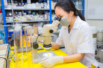 An Asia scientific researcher holding at a liquid solution in a lab.