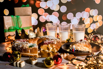 "Rosc&oacute;n de reyes" is a traditional Spanish Epiphany cake with decorative candied fruit and cream filling. Good luck figure inside. The Spanish concept of Three Kings Day. Three glasses of milk.