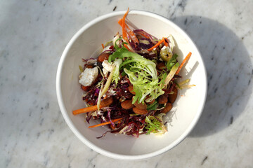 Top view image of a bowl of salad with roasted almond nuts