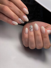 The work of a manicure master. Hands of a beautiful young woman and modern design.
