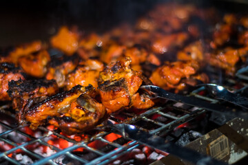 Delicious Grilled Tandoori of Assorted Meats over Charcoal and hot grill on Skewers - obrazy, fototapety, plakaty