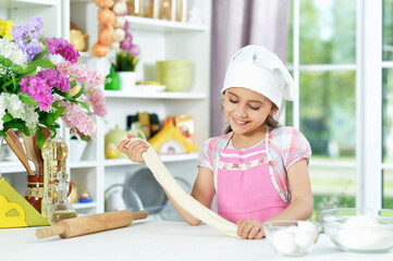 Cute girl making dough in the kitchen