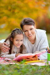 Mother and daughter with books in park