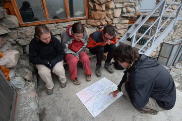 Group of trekkers backpackers consulting map. Navigation. Orientation in mountains. Ala Archa...