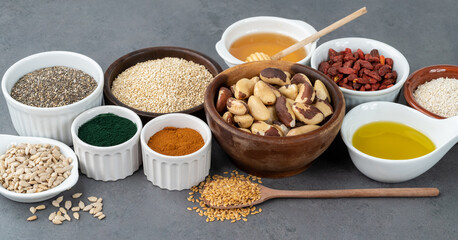 Assorted superfoods over stone background. Chia, quinoa, oat, linseed, honey, spirulina and others