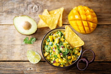Mango Guacamole with corn chips and ingredients to prepare it