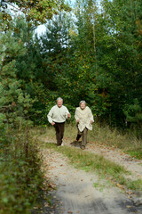 Portrait of senior couple walking in autumn forest