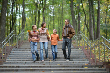 Family of four walking in autumn park